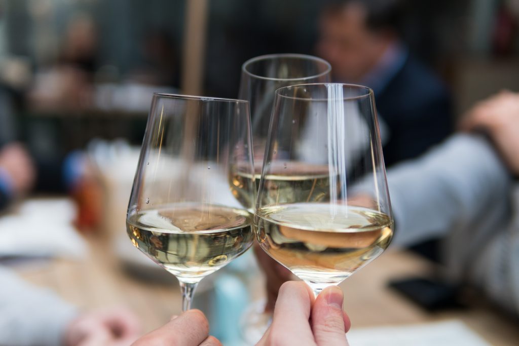 Stock photo of three people drinking wine.