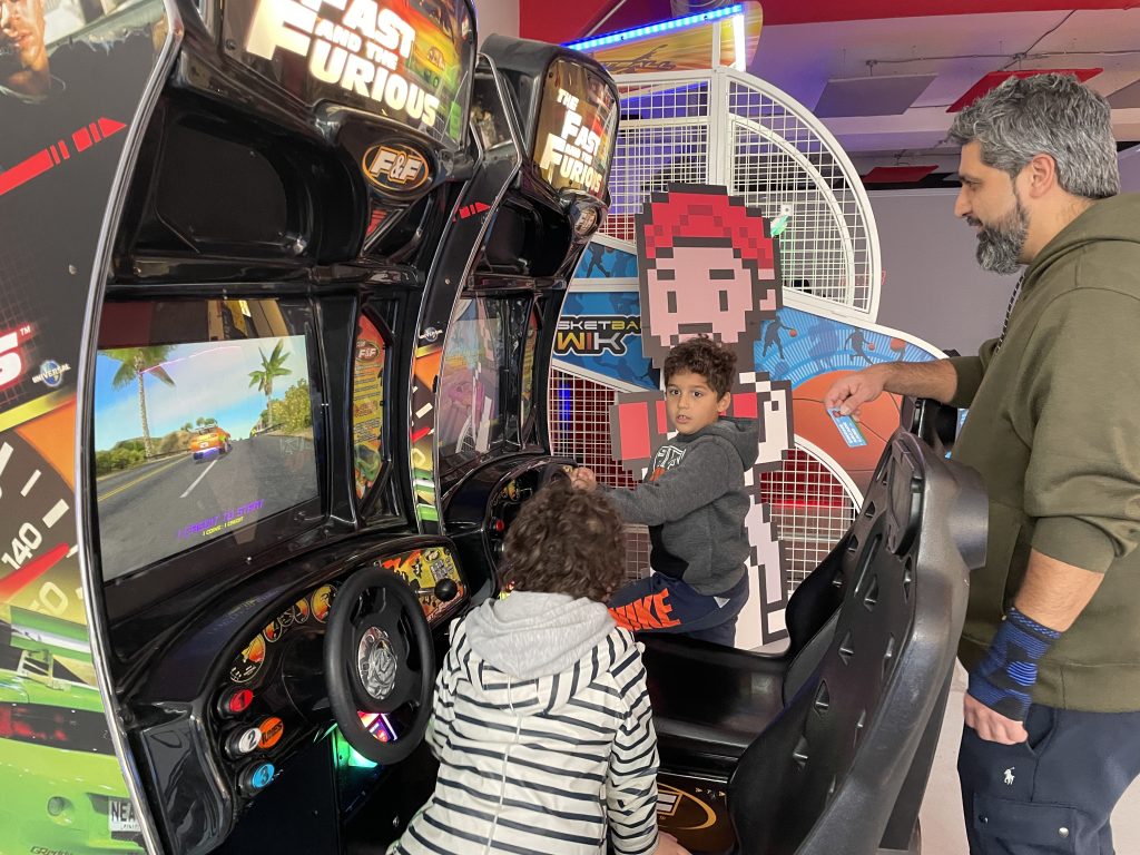 Arcade goers enjoying the fast and furious racing game.