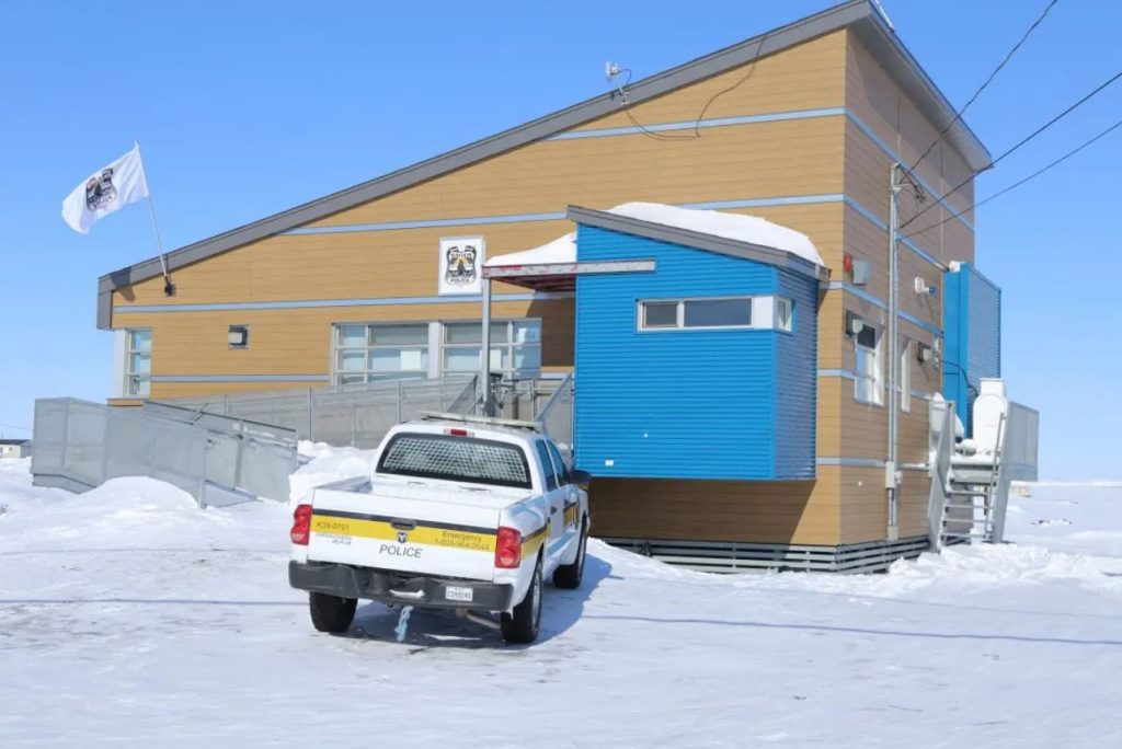 snow on ground, truck parked outside police station