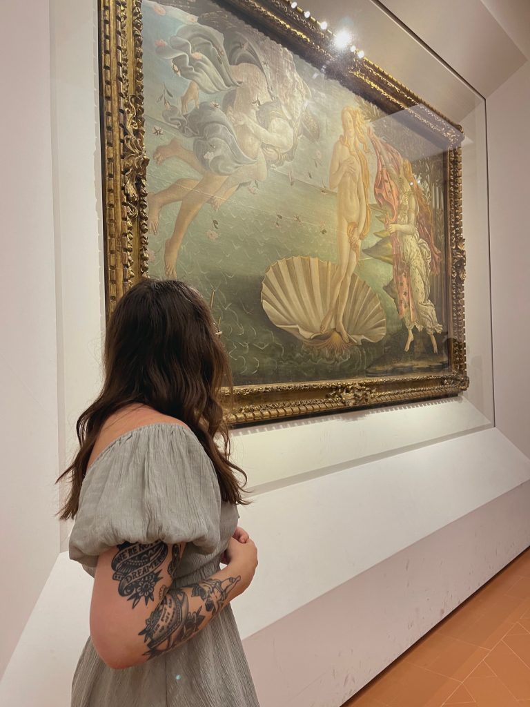 woman standing and staring at a painting