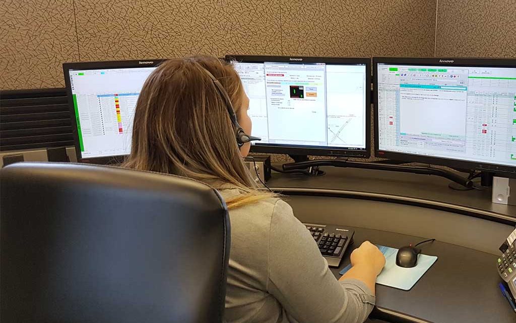 woman sitting in front of three computer monitors