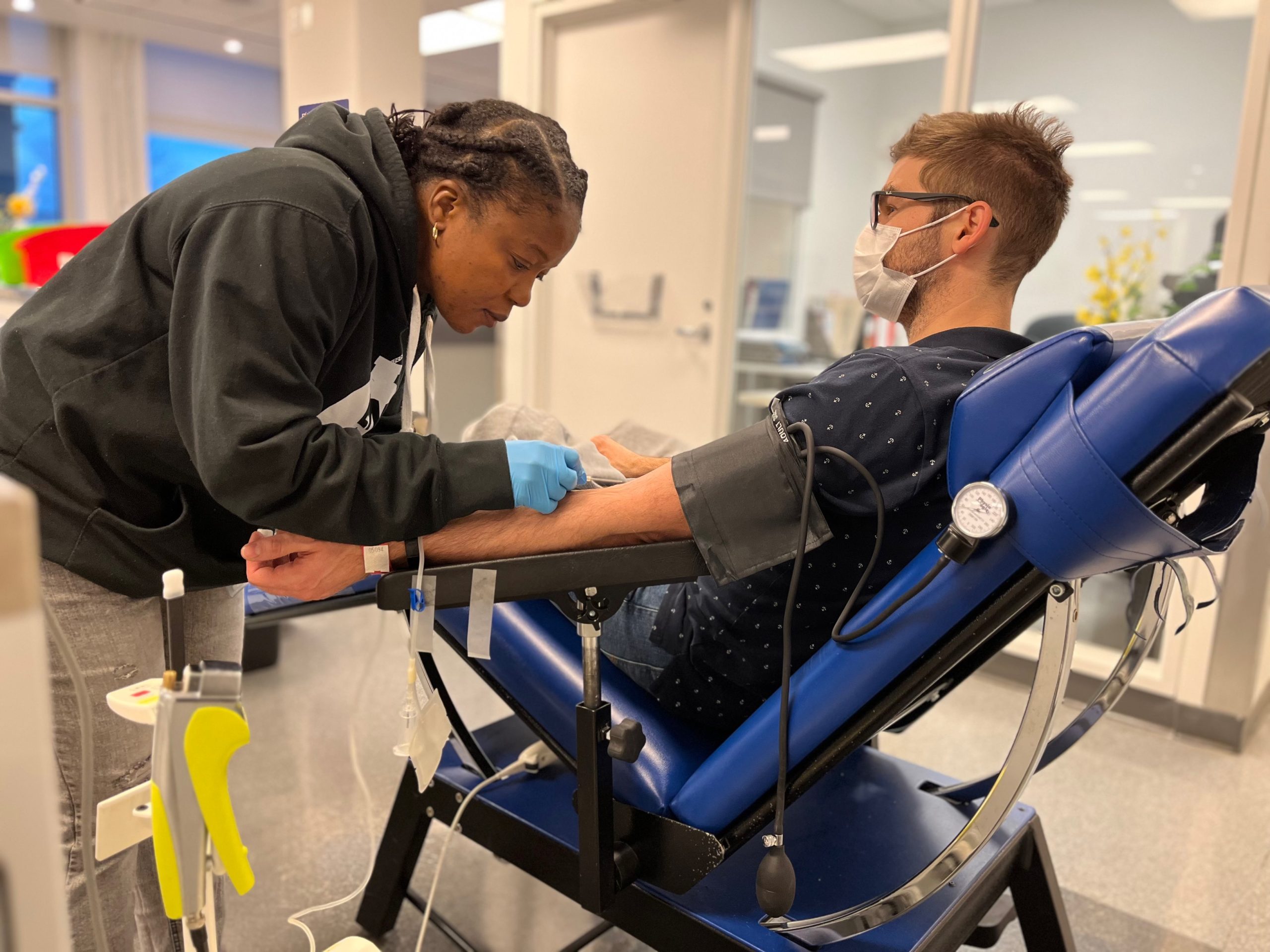 female nurse drawing blood from man's arm