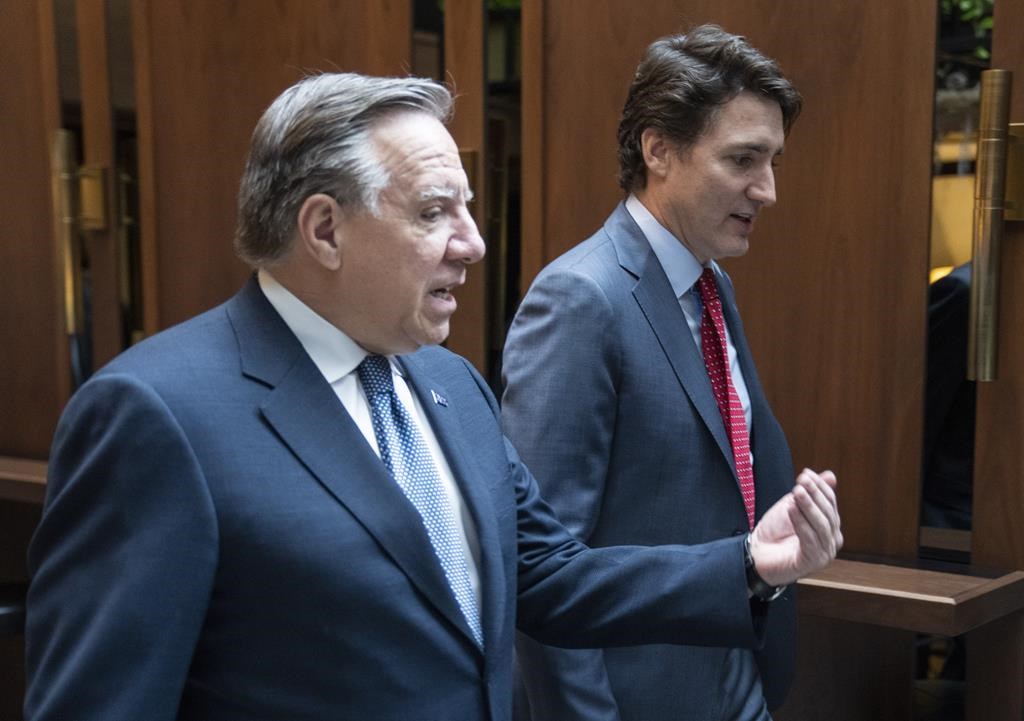 Prime Minister Justin Trudeau (right) and Quebec Premier Francois Legault (left) are seen together in a meeting talking in Montreal, Dec. 20, 2022.