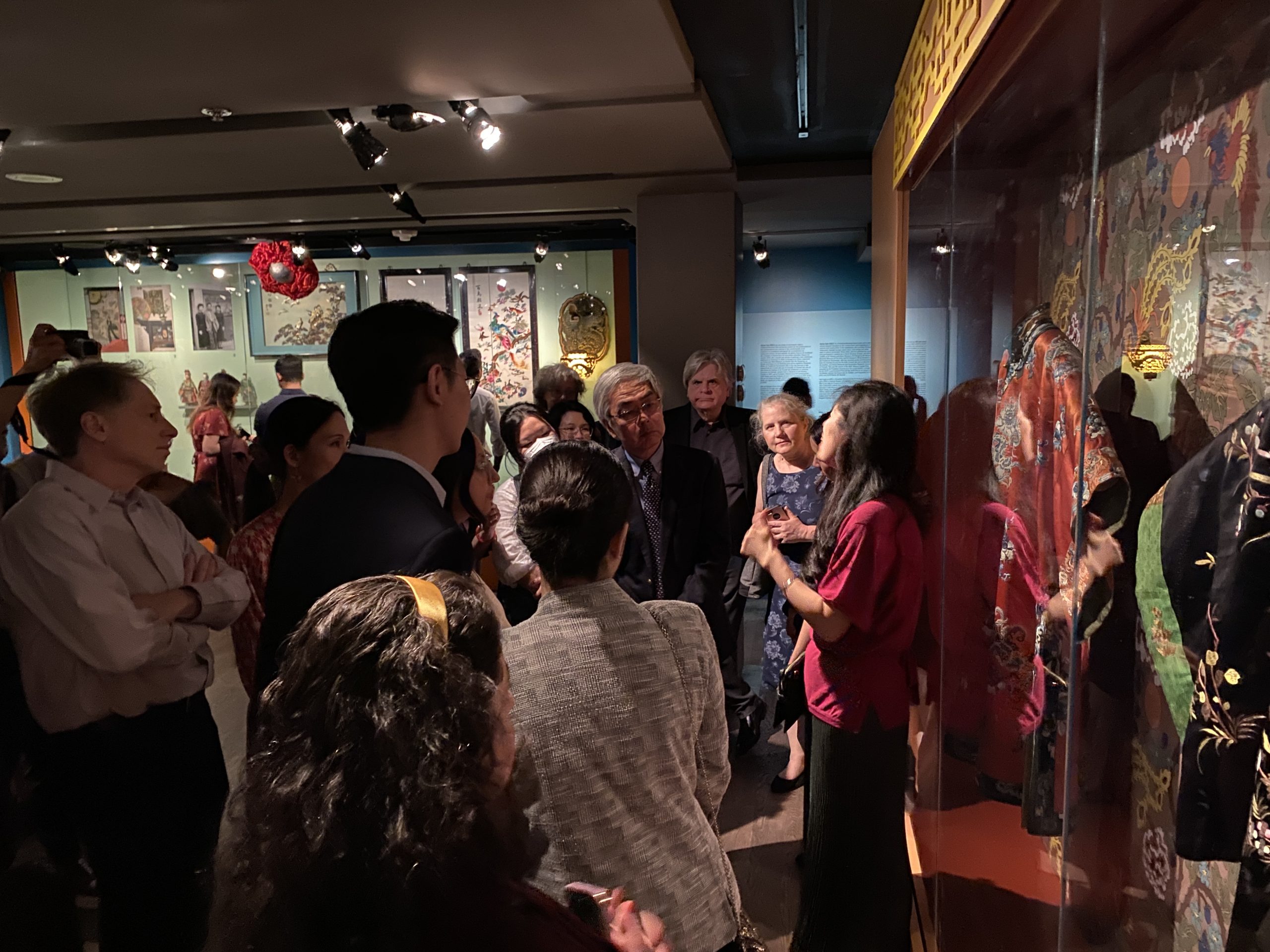 Gente escuchando atentamente las explicaciones de Karen Tam sobre las obras de arte y los archivos.