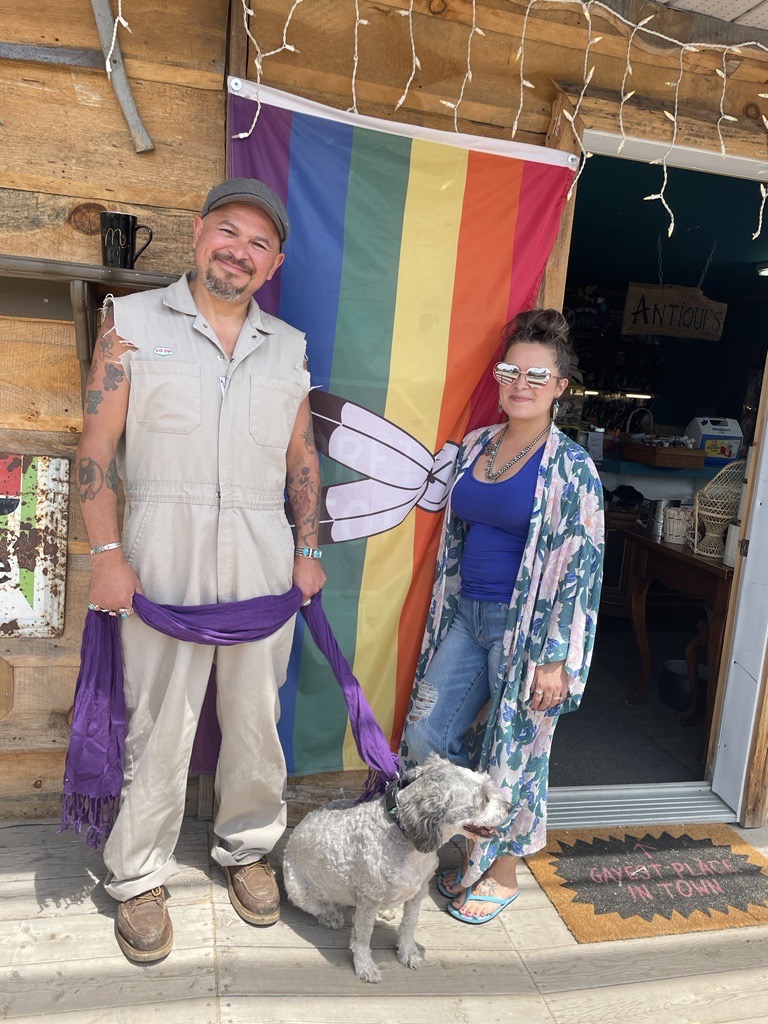 Lanny and Lacey Lazare in front of their store, standing in front of a Pride Flag