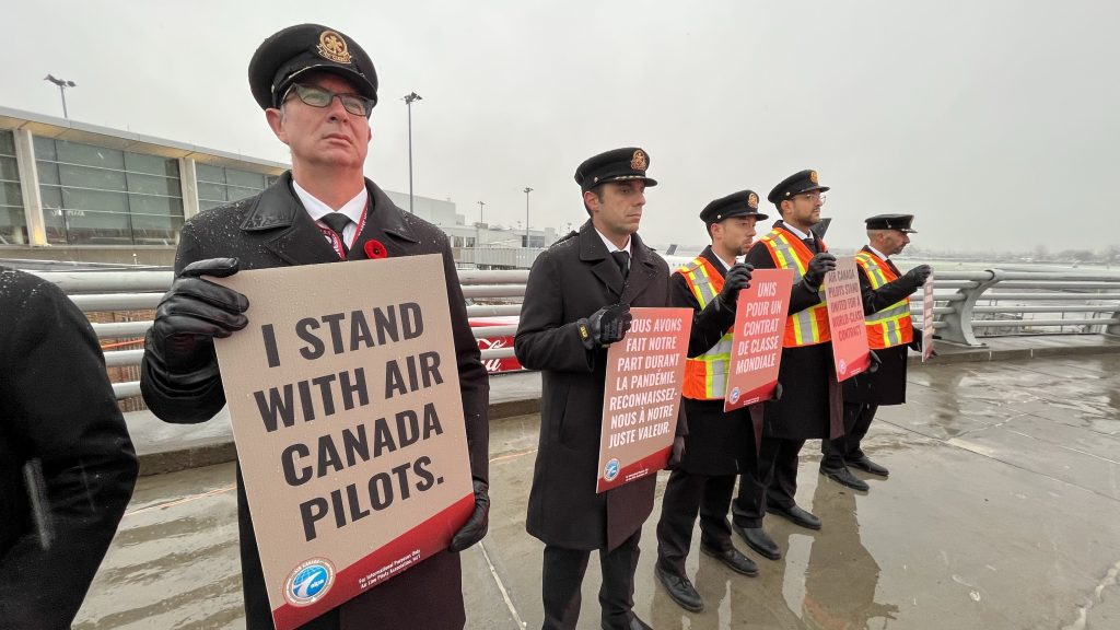 pilots holding up protest posters