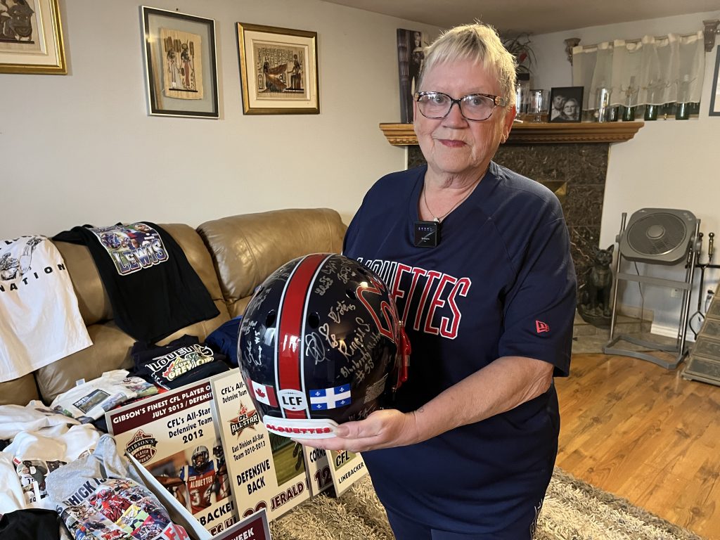 Heather Lowengren con el casco firmado de los Montreal Alouettes que le regalaron los jugadores tras la muerte de su marido