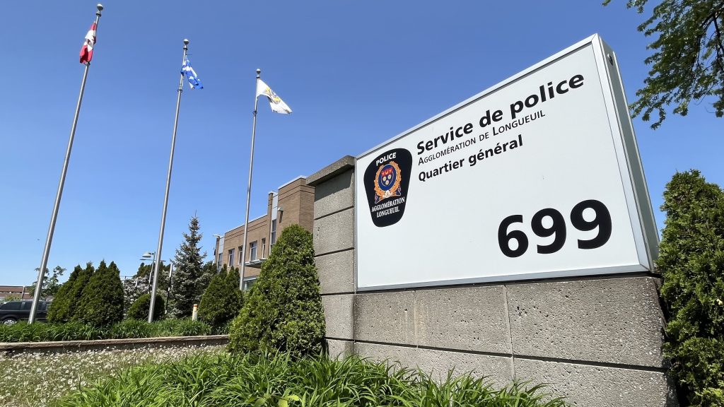 The Longueuil police is seen in daylight with flags flowing on May 23, 2023. Martin Daigle