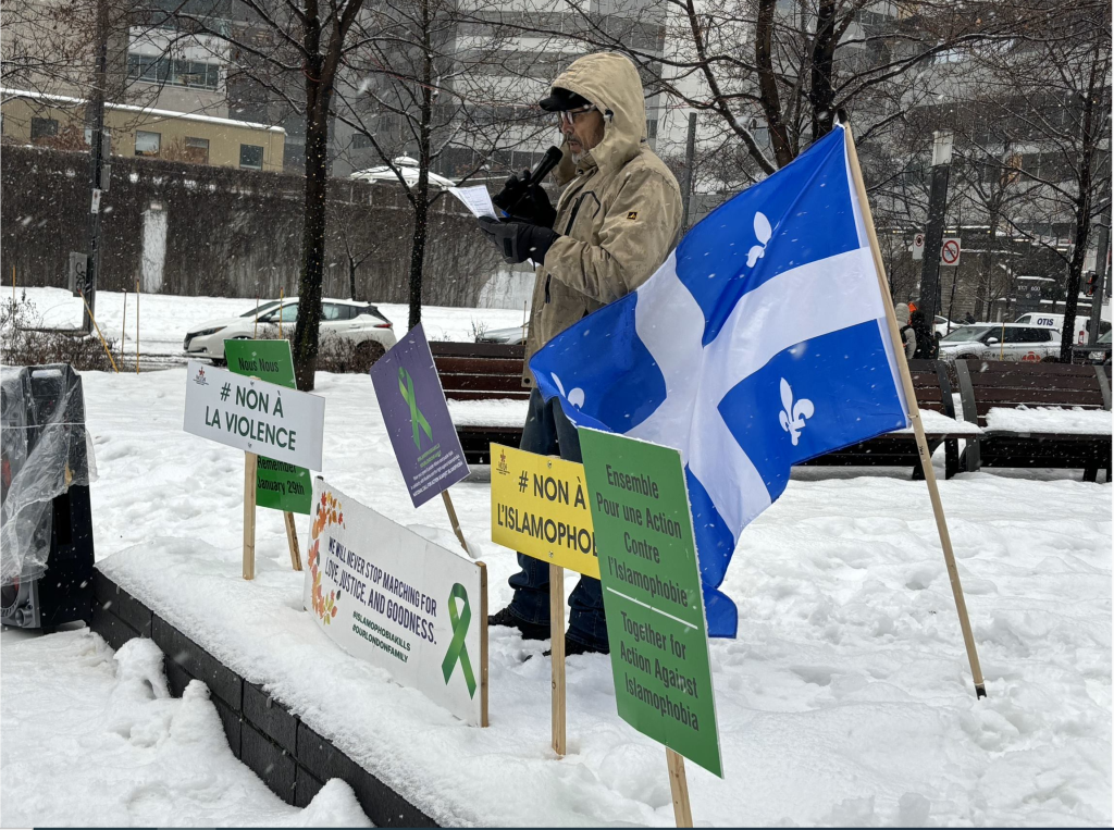A quebec flag and other signs are seen in the snow at Square Victoria