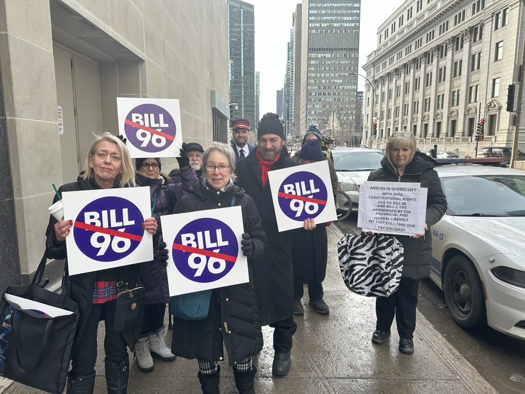 A group of protesters is seen holding anti Bill 96 signs