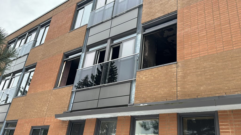 The building of an apartment fire in Pointe-aux-Trembles is seen with window damage