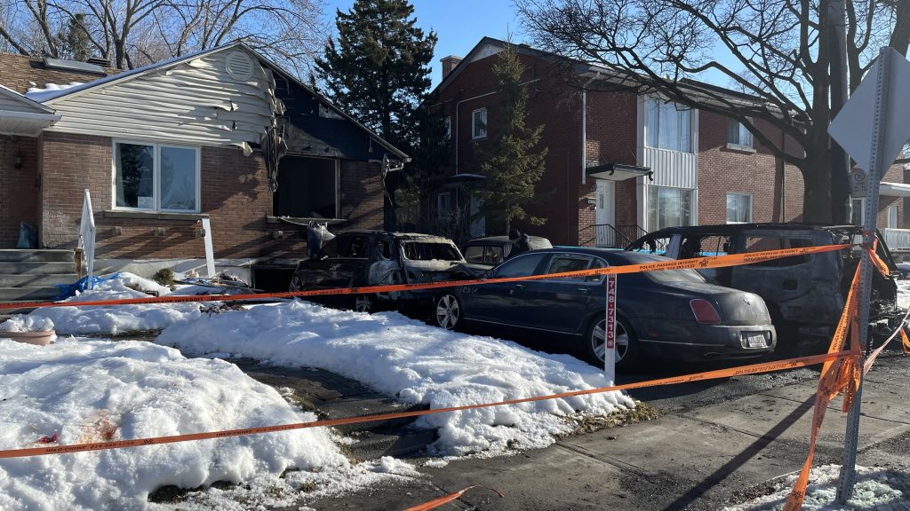 An overview of fire damage to a home and cars are seen