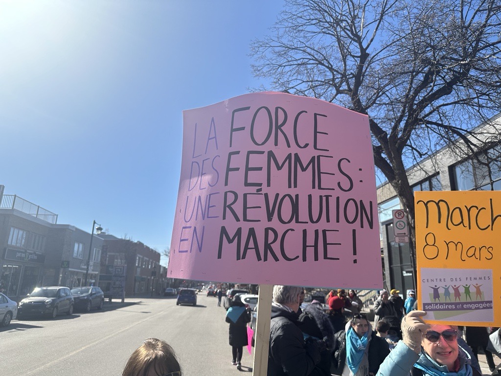 A sign is seen at a march for International Women's Day in Ahuntsic