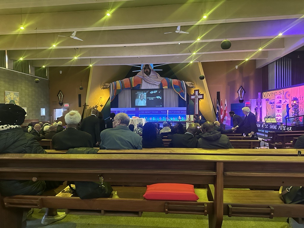People are seated at the Holy Family Church