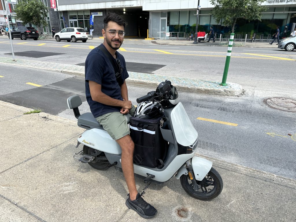 Tarek Ould Ali , an international student who delivers food on his electric moped.