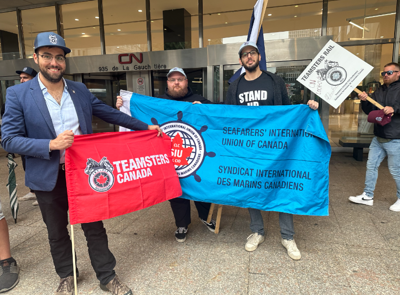 Rail workers pose with flags outside CN headquarters