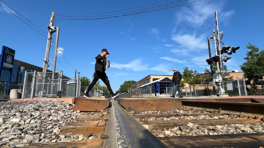 Person crosses exo Parc station train tracks