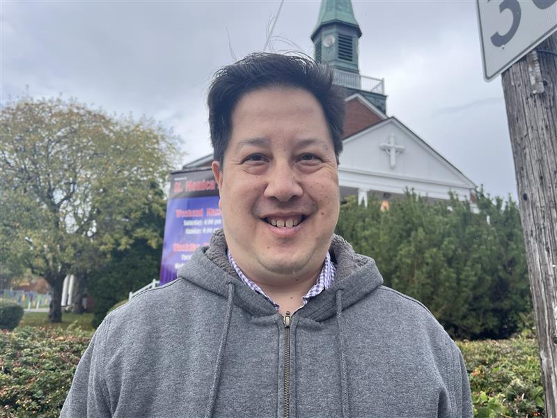 Paul Wong poses for a photo in front of St. Monica's Catholic Church