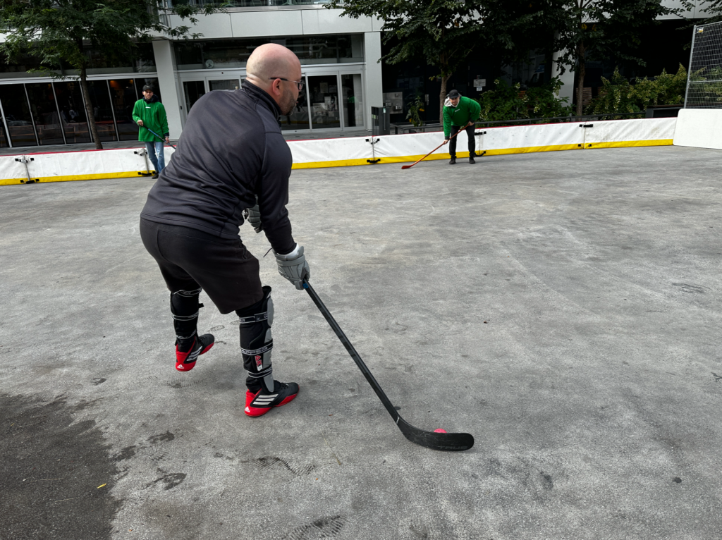 a man holds a hockey stick in an outdoor rink