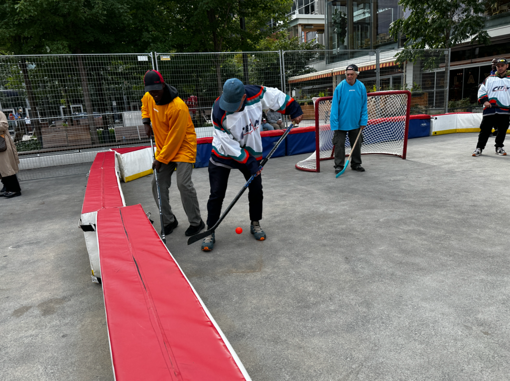 two players are seen fighting for the ball in street hockey