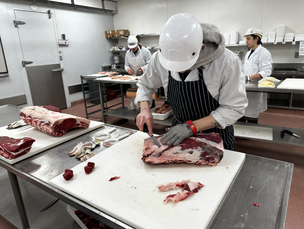 students are seen cutting meat
