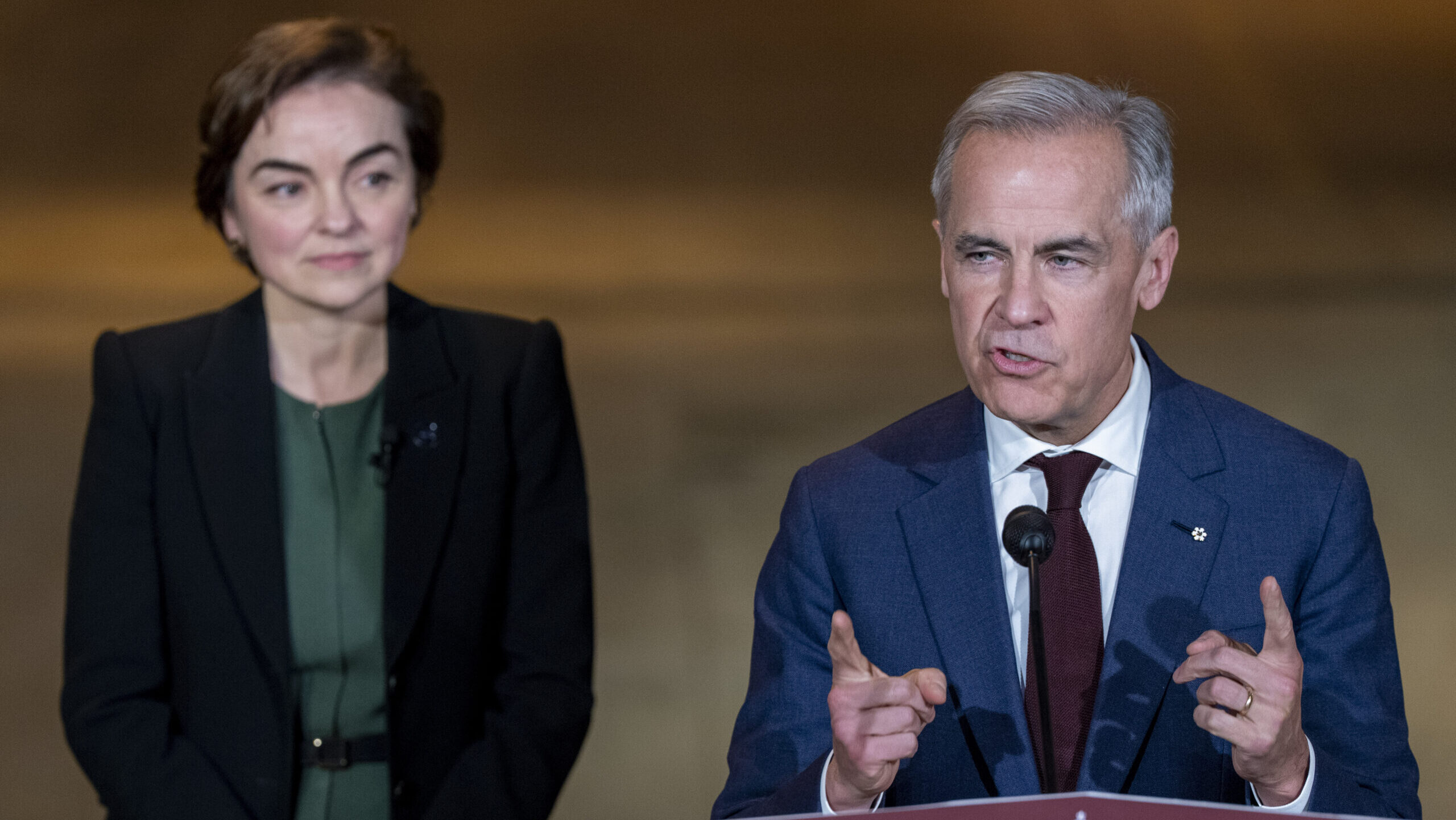 Prime Minister Mark Carney, right, makes an announcement on infrastructure funding at the Reseau de transport de l'agglomeration de Longueuil (RTL) garage as Quebec Premier Christine Frechette looks on, in Longueuil, Que., on Tuesday, June 2, 2026. THE CANADIAN PRESS/Christinne Muschi